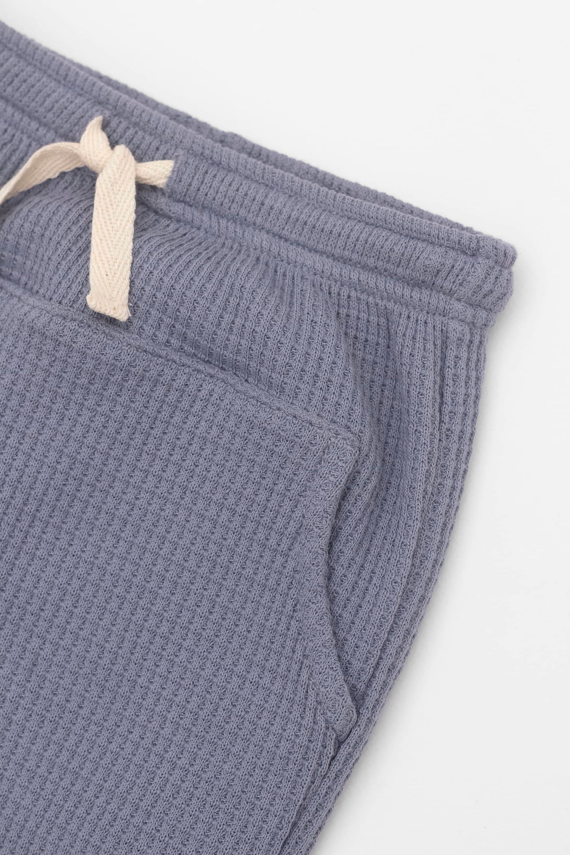 Blue moon joggers with elasticized waist, drawstring and kangaroo pocket. Front detail