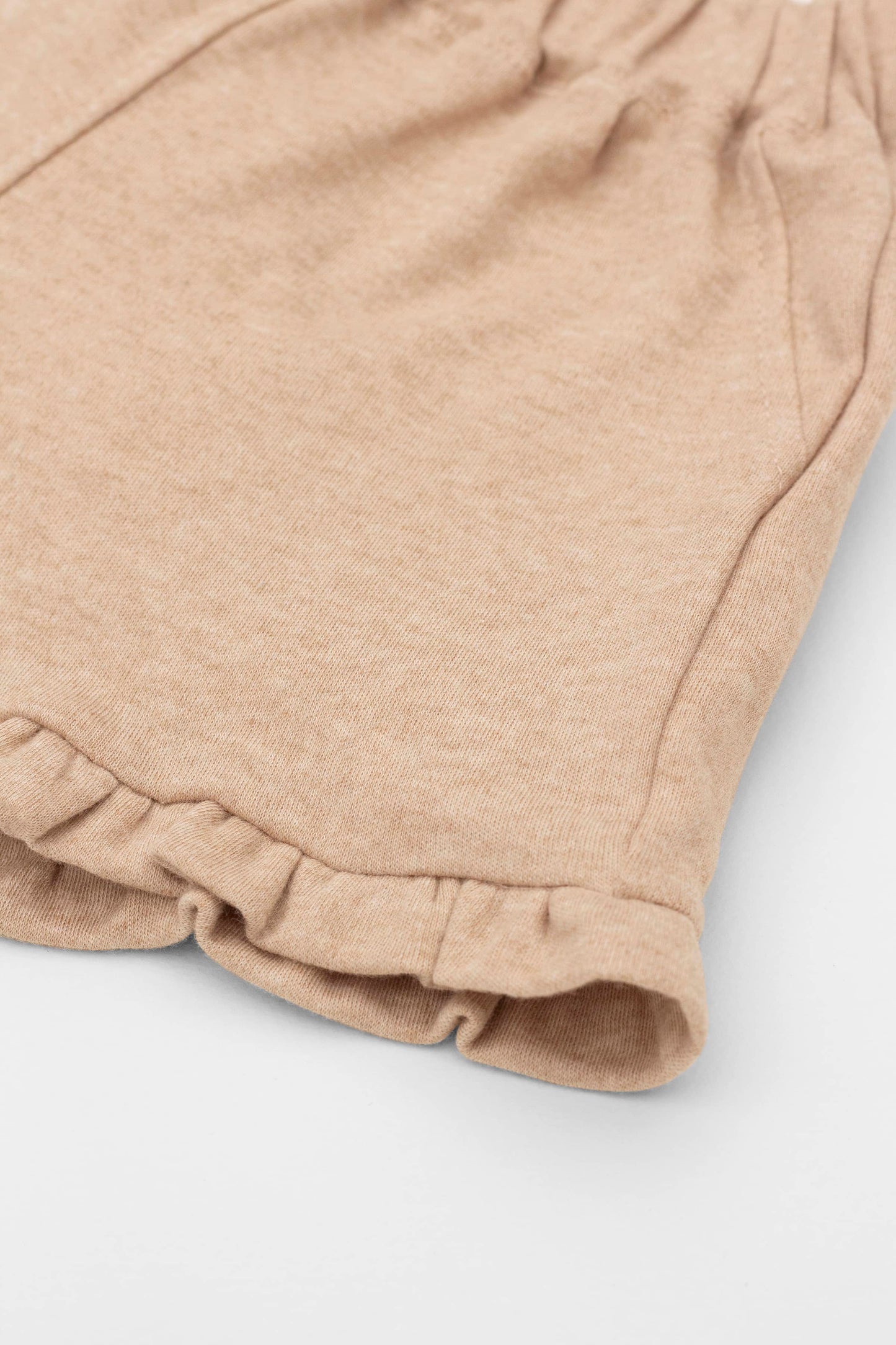 Organic pima cotton shorts with ruffle hem, elasticized waist and fake pockets. Sand. Ruffle detail