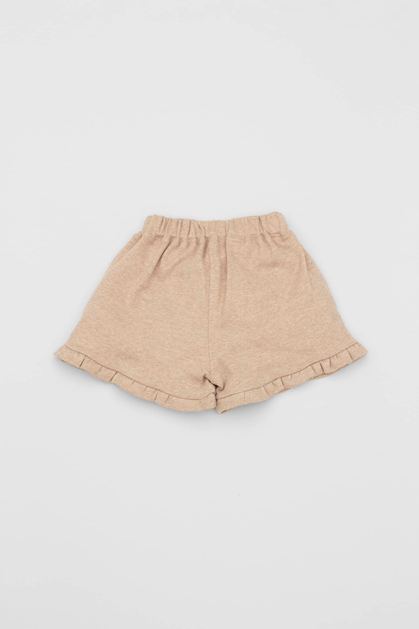 Organic pima cotton shorts with ruffle hem, elasticized waist and fake pockets. Sand. Back view