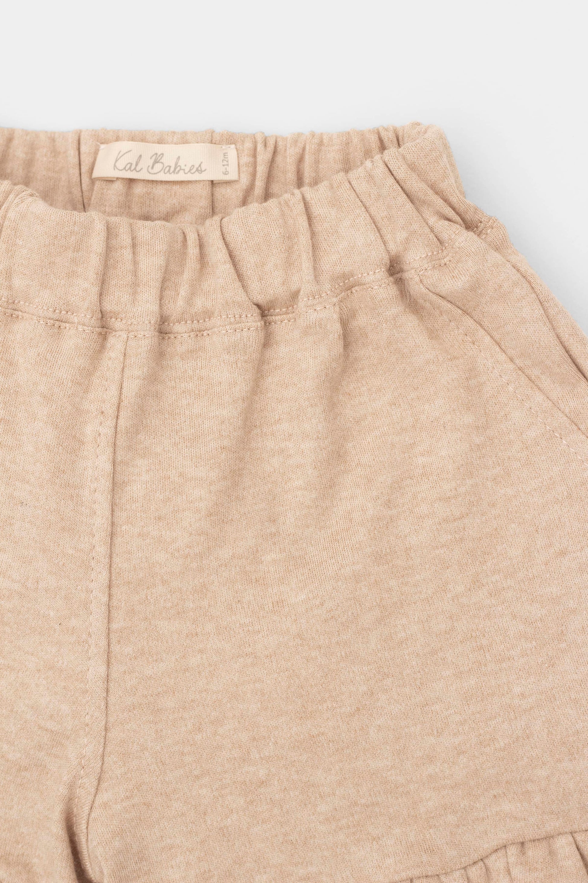 Organic pima cotton shorts with ruffle hem, elasticized waist and fake pockets. Sand. Front detail