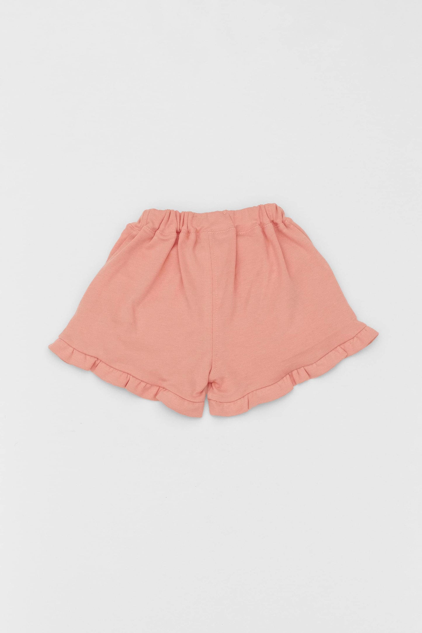 Organic pima cotton shorts with ruffle hem, elasticized waist and fake pockets. soft melon. Back view