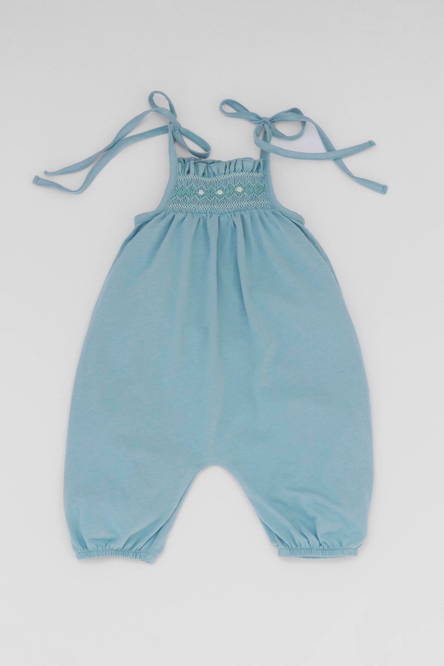 Smocked blue organic romper with straps and embroidery