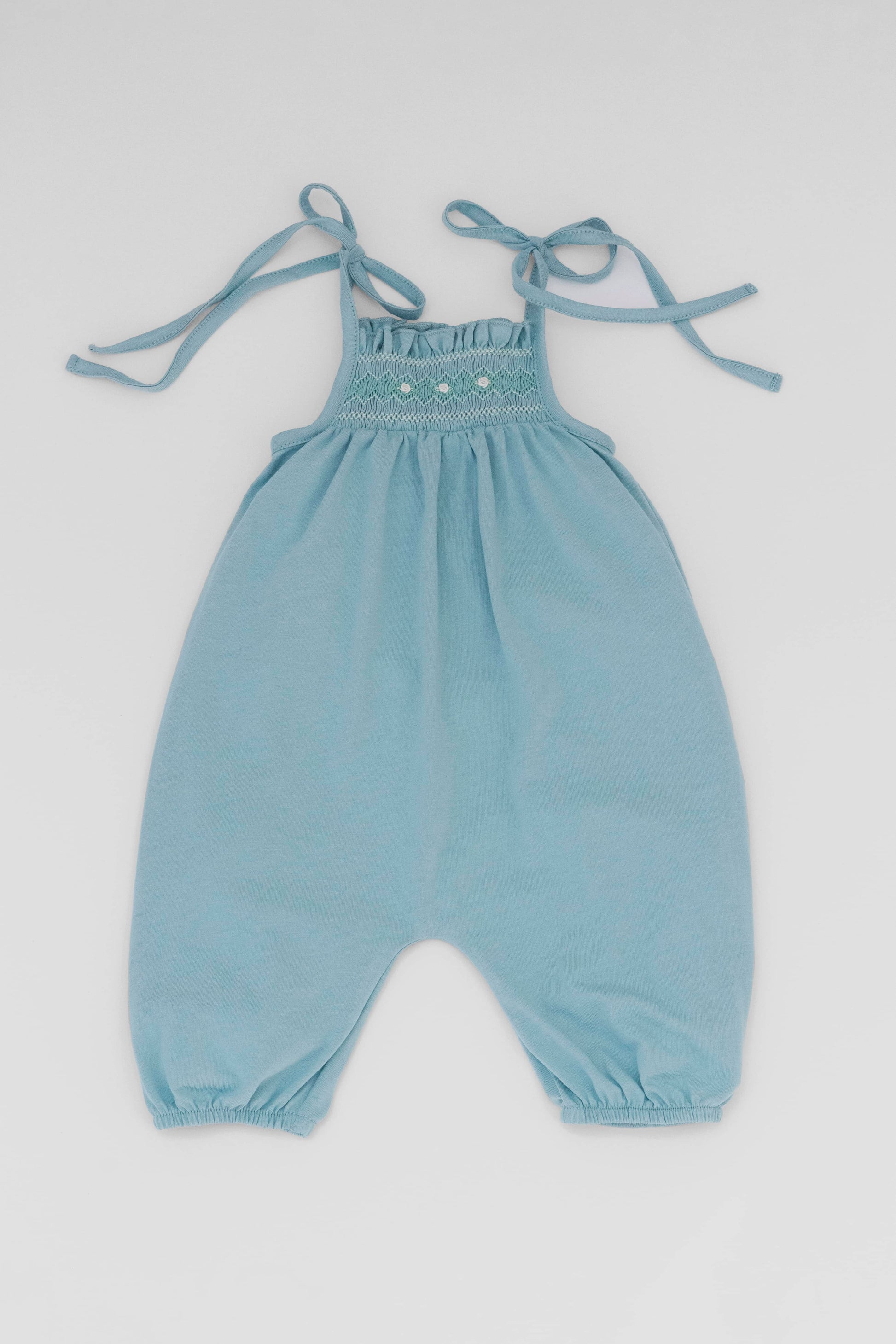 Smocked blue organic romper with straps and embroidery