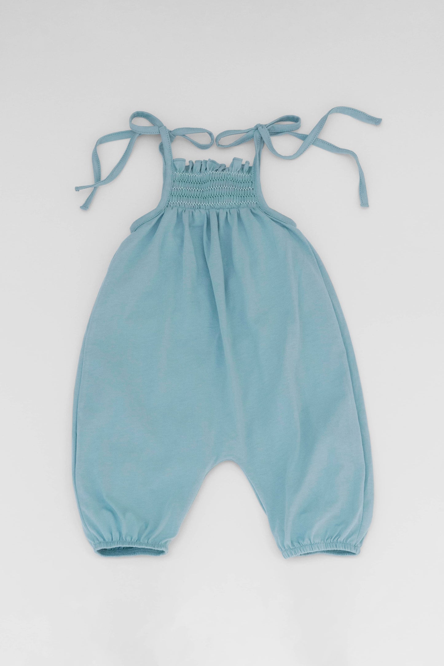 Smocked blue organic romper with straps and embroidery