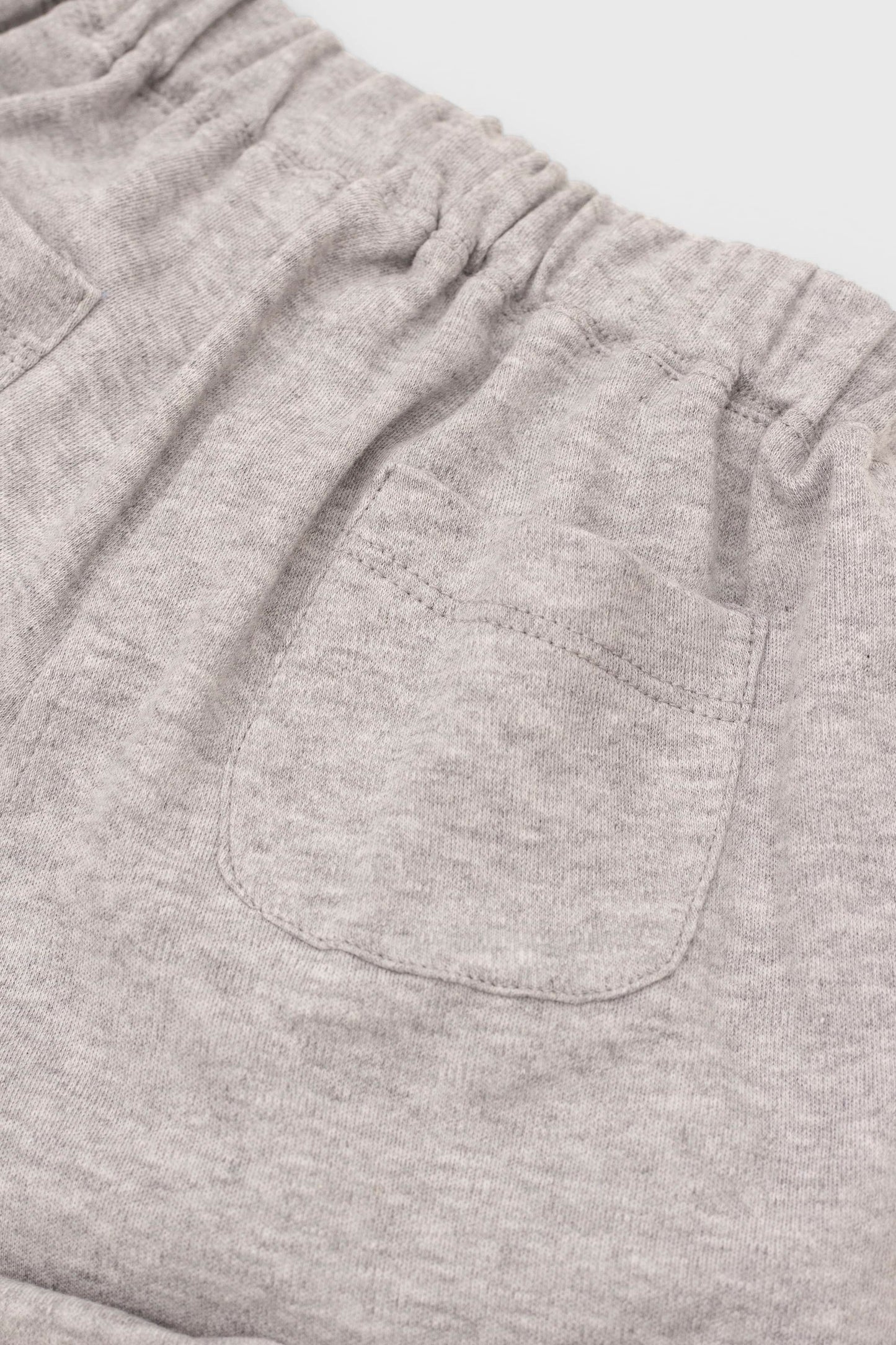 Grey organic cotton shorts with folded hem and back patch pockets. Back pockets detail