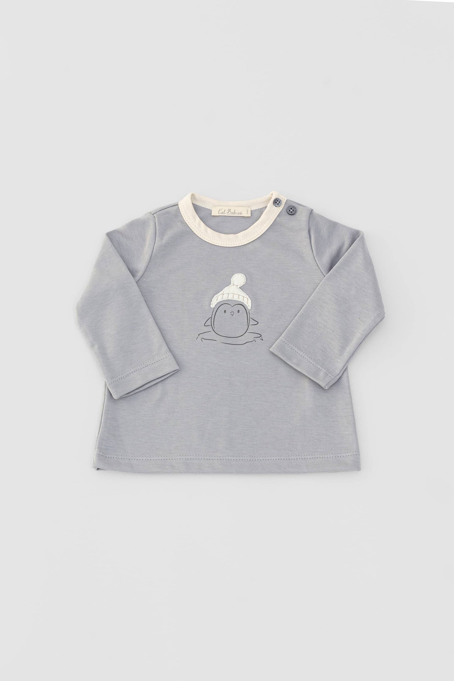 Long sleeve crewneck top with buttons at shoulder. Printed penguin with beanie appliqué. Grey/natural organic pima cotton. Front view