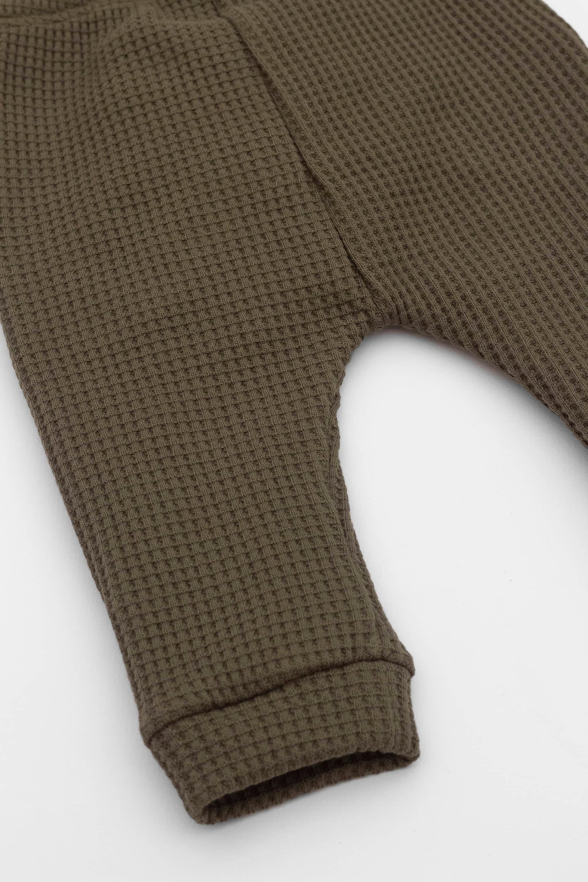 Olive joggers with elasticized waist, drawstring and kangaroo pocket. Leg detail