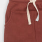 Pottery joggers with elasticized waist, drawstring and kangaroo pocket. Front detail