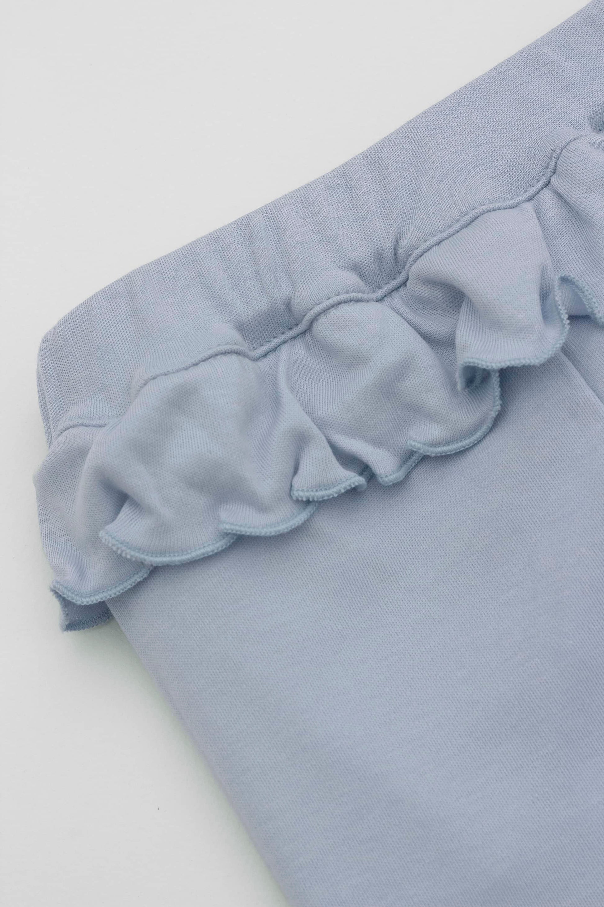 Baby blue leggings with ruffled accent on the waistband. Front detail