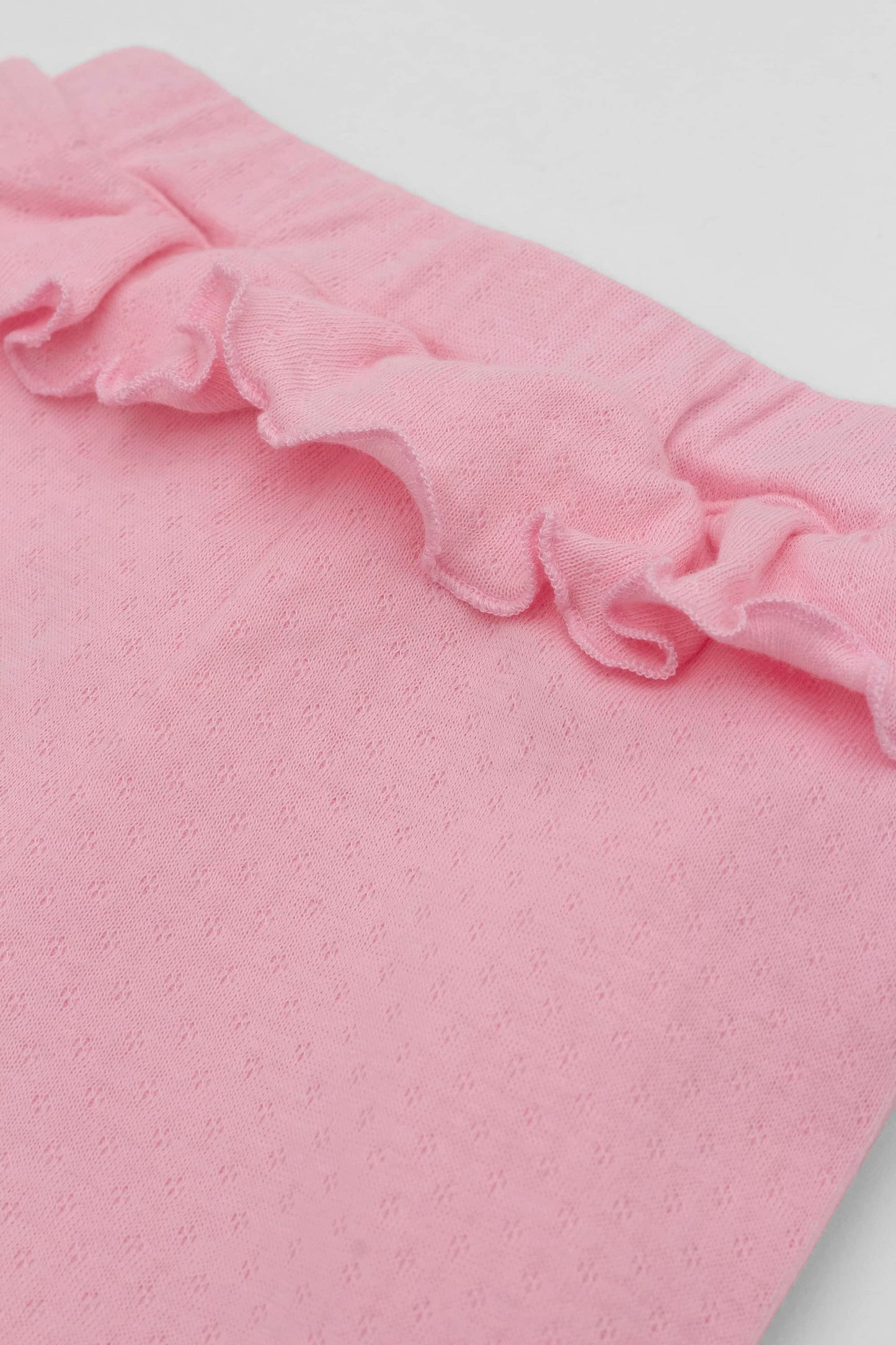 Pink leggings with ruffled accent on the waistband. Front detail