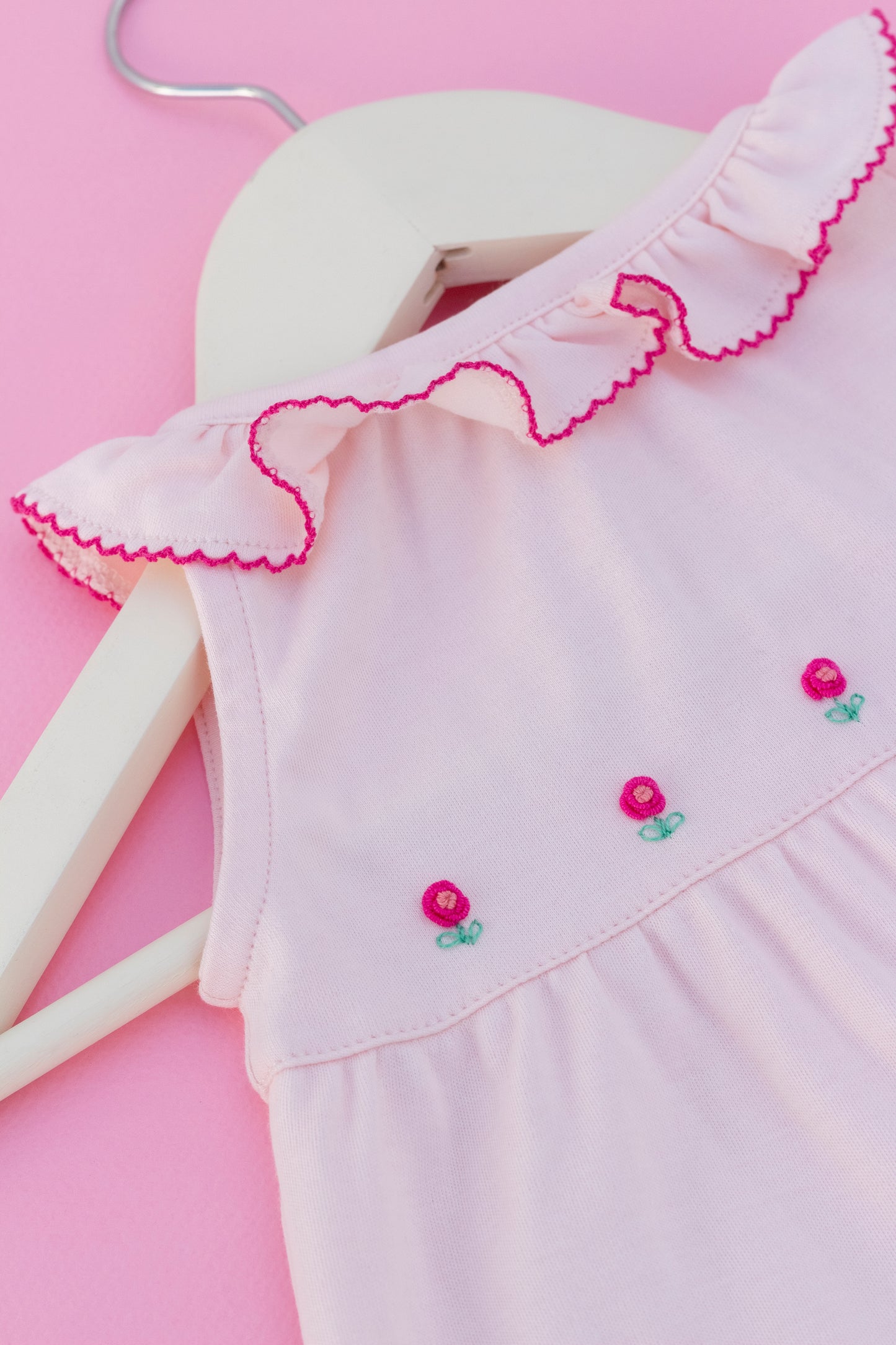 Pink romper with hand embroidered flowers
