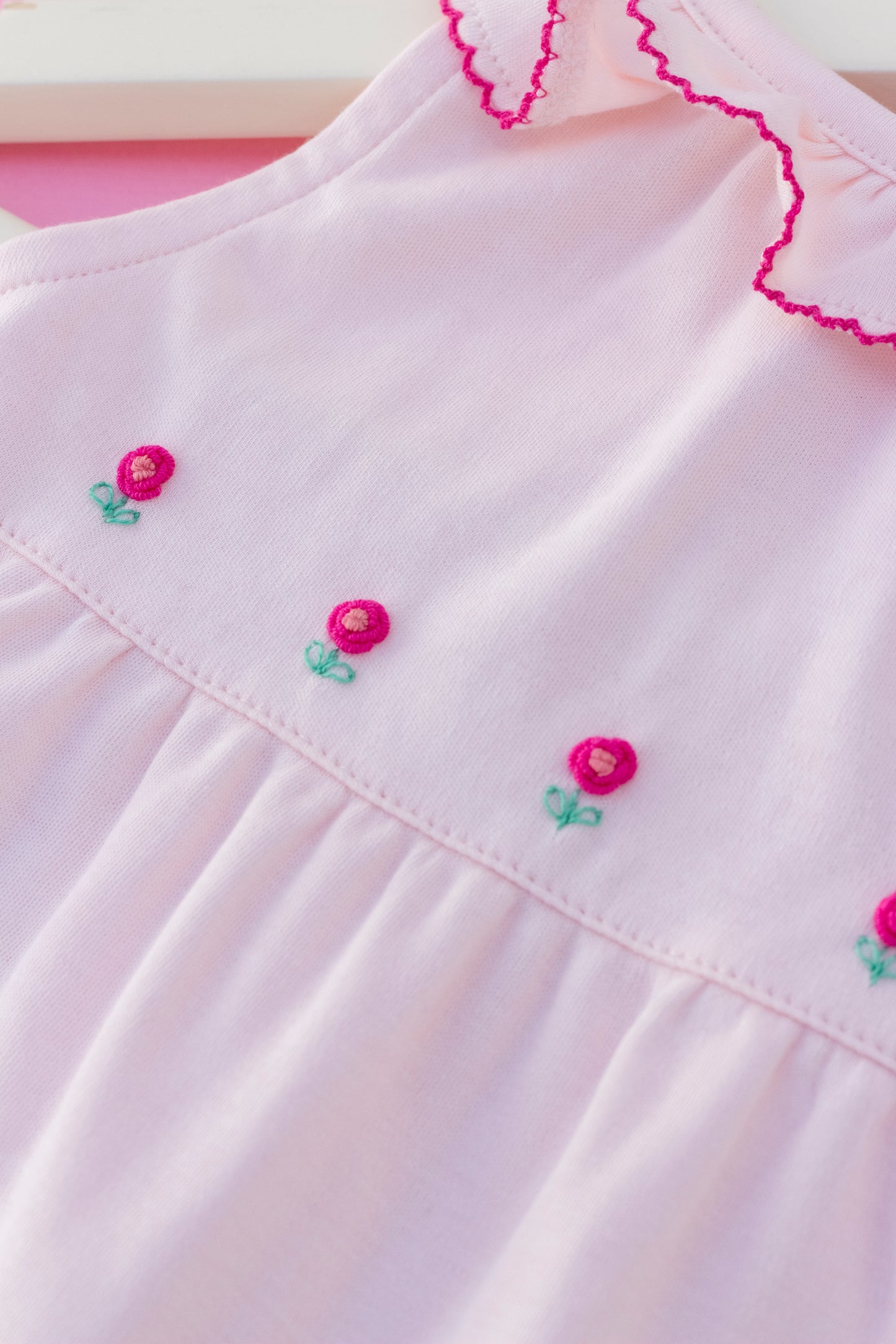 Pink romper with hand embroidered flowers