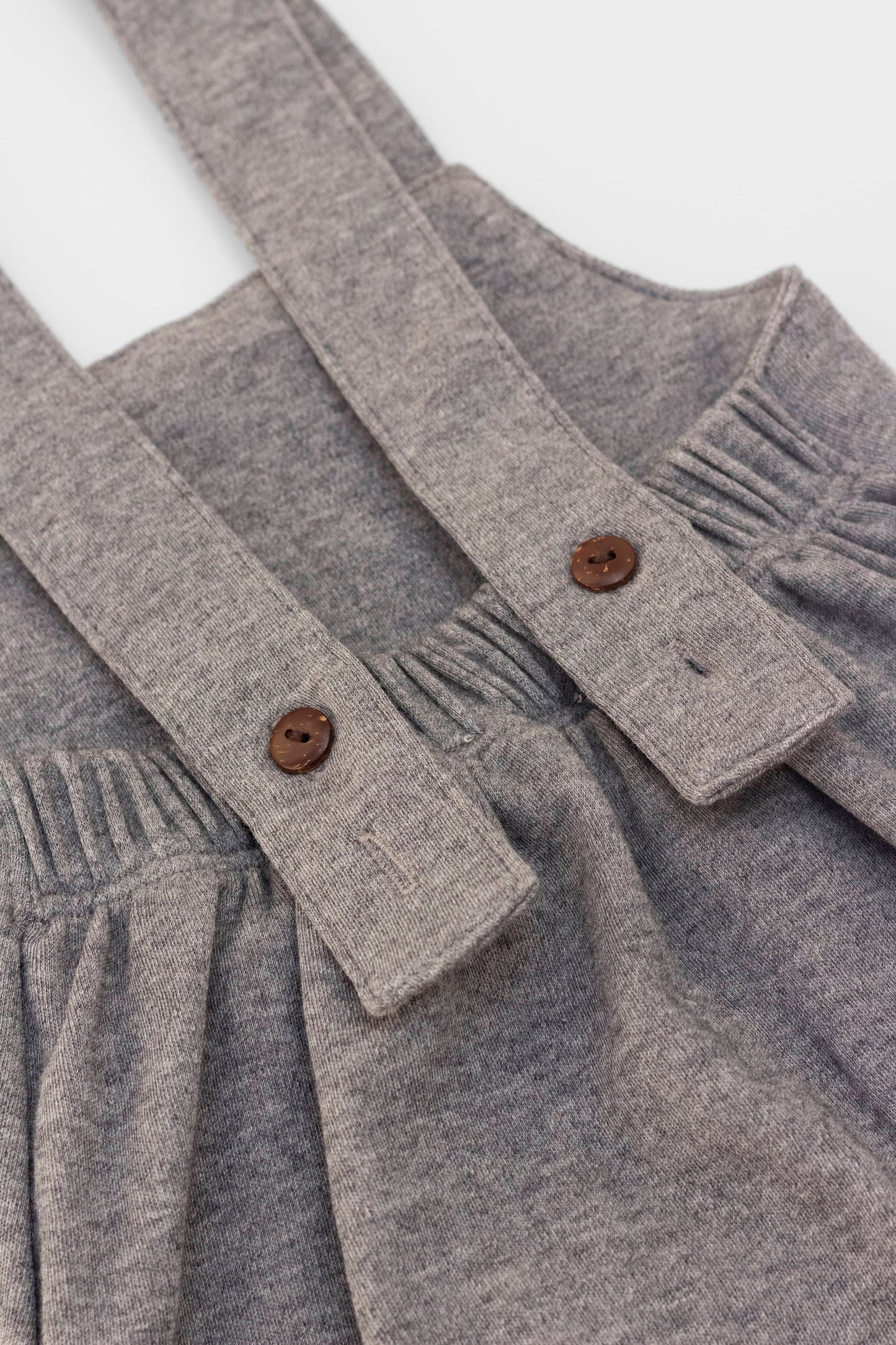 Organic-cotton overall with wooden buttons.