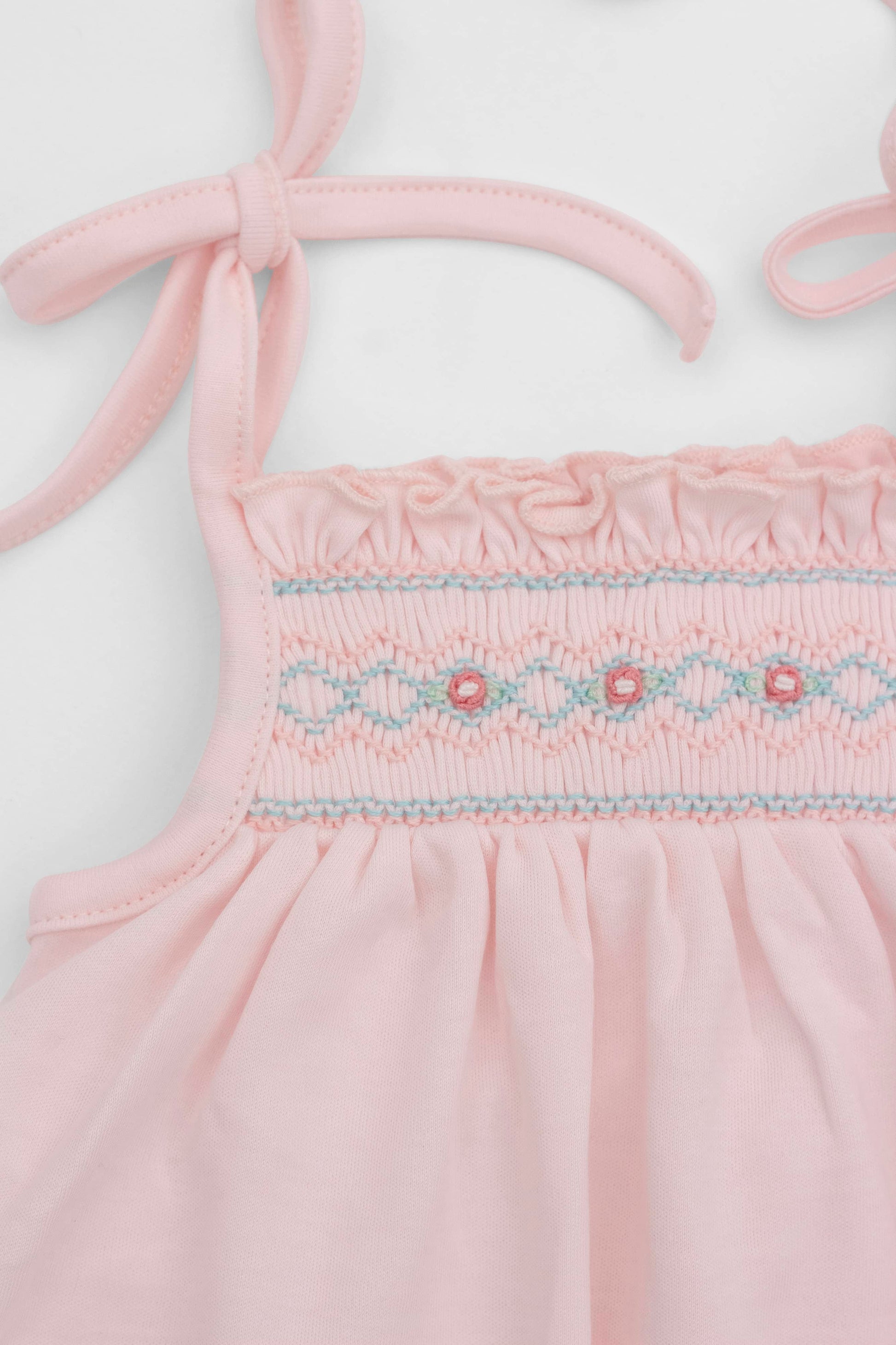 Smocked pink organic romper with straps and embroidery - detail