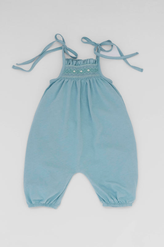 Smocked blue organic romper with straps and embroidery