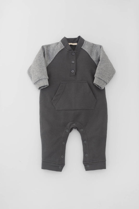 Long raglan sleeve romper with kangaroo pocket. Buttoned fasting on front. Contrasting sleeves and snap buttons. Stone and heather grey. Front view