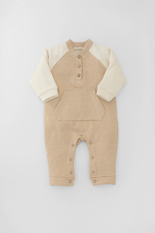 Long raglan sleeve romper with kangaroo pocket. Buttoned fasting on front. Contrasting sleeves and snap buttons. Camel stripes and oatmeal. Front view